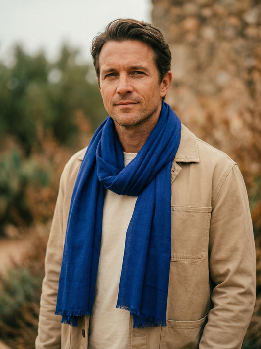 Man wearing indigo Moroccan Tagelmust as a breathable travel scarf, ideal for hot climate trekking and desert dust protection.