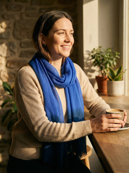 Indigo blue Tagelmust styled as a lightweight travel scarf for women, Touareg inspired Moroccan headscarf ideal for hot climate safari and sun protection.