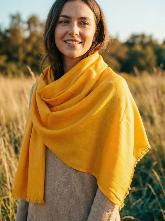 Sunglow orange Tagelmust styled as a lightweight travel scarf for women, Touareg inspired Moroccan headscarf ideal for safari adventures, sun protection, and warm desert climates.