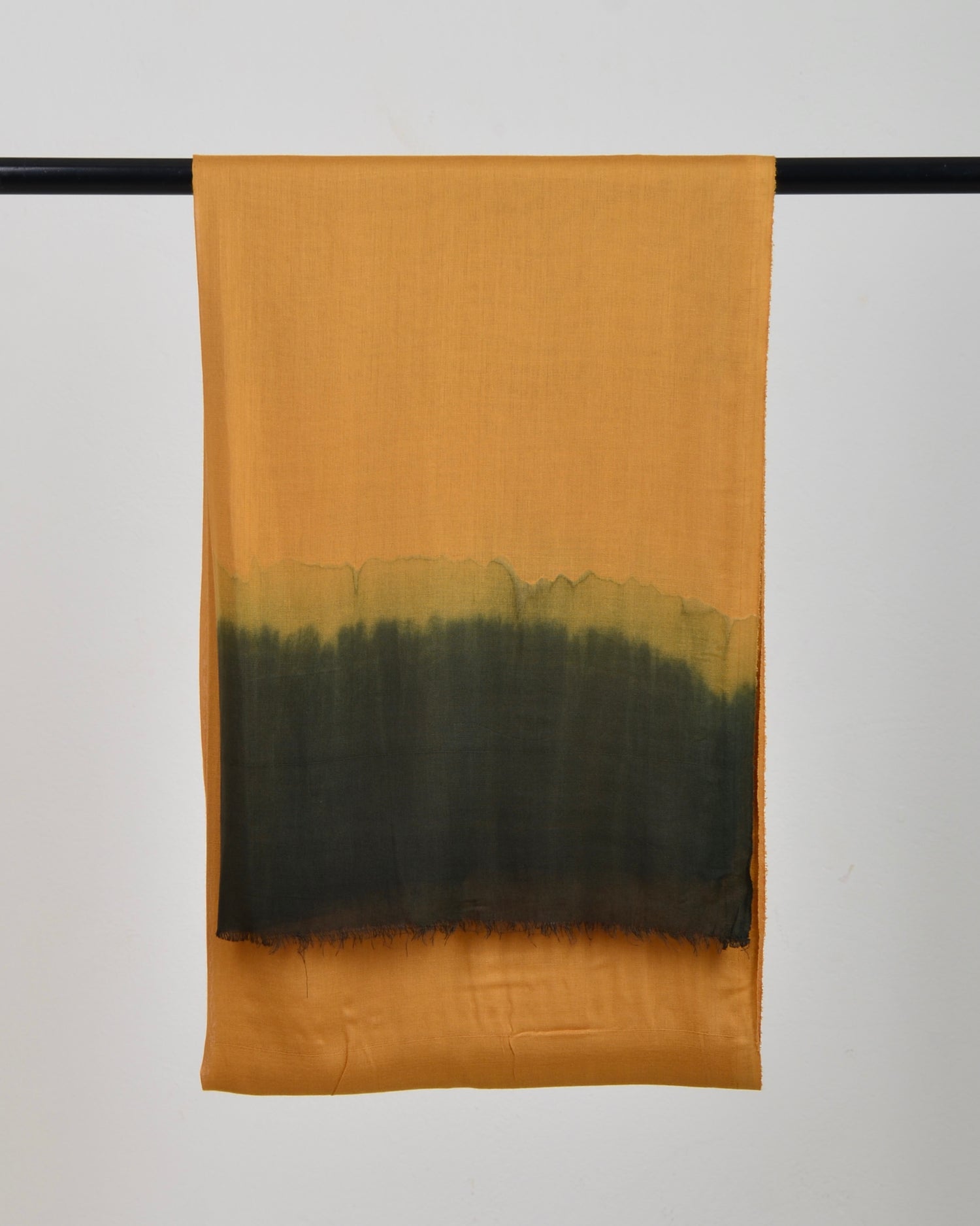 Harvest Gold Soaked Tagelmust scarf draped on a rod – warm mustard‑gold fabric fading into olive green gradient, sustainably sourced lightweight Moroccan headscarf ideal for nomadic travelers seeking gold, mustard, or olive scarves for hot‑weather, dry‑climate adventures.