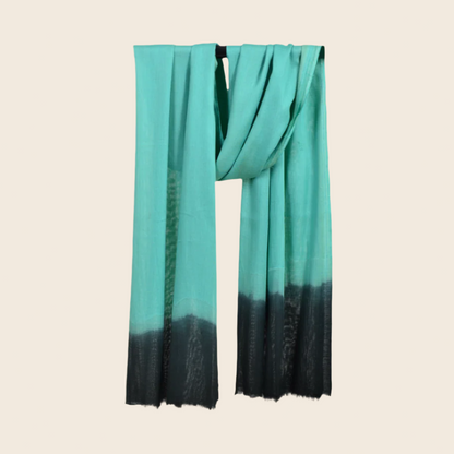 Sea Green Soaked Tagelmust scarf – vibrant teal / sea‑green hanging wrap fading to deep black gradient. Sustainably sourced lightweight Moroccan headscarf, ideal for nomadic travelers searching for teal, turquoise, or black scarves for hot‑weather, dry‑climate adventures.